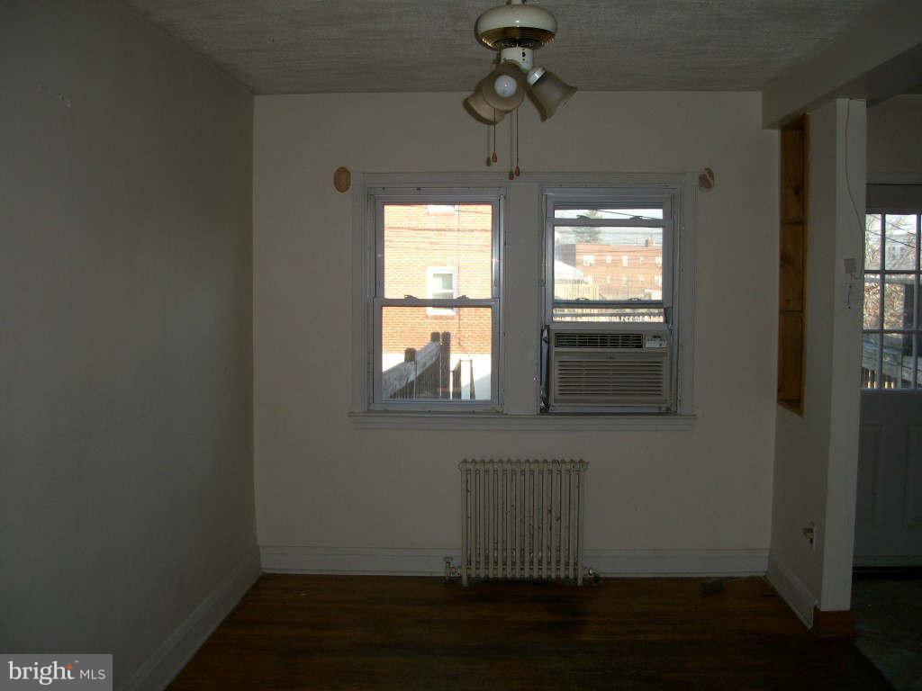 15 Warren Road Baltimore, MD 21221 - Photo 2 of 10 a view of empty room with wooden floor and fan