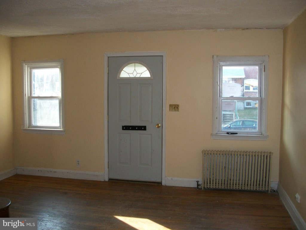 15 Warren Road Baltimore, MD 21221 - Photo 3 of 10 an empty room with wooden floor and windows
