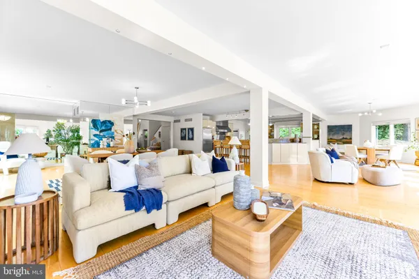 a living room with furniture kitchen view and a large window
