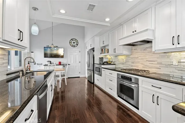 a kitchen with stainless steel appliances a stove sink microwave and cabinets