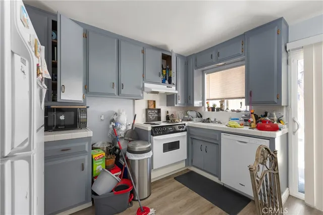 a kitchen with a white stove top oven sink and cabinets