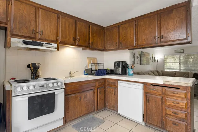 a kitchen with cabinets appliances a sink and a counter