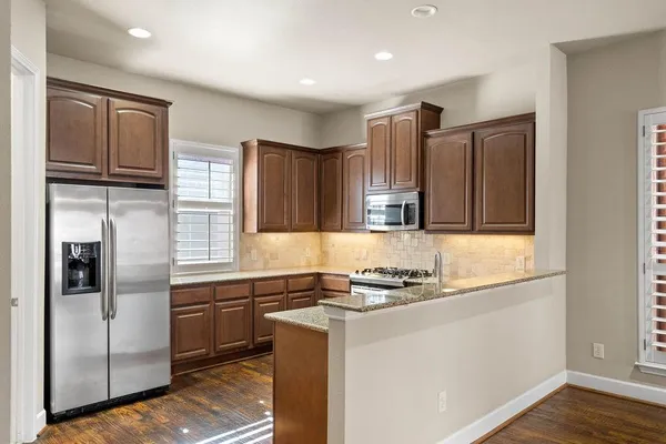 a kitchen with stainless steel appliances granite countertop a refrigerator and a sink