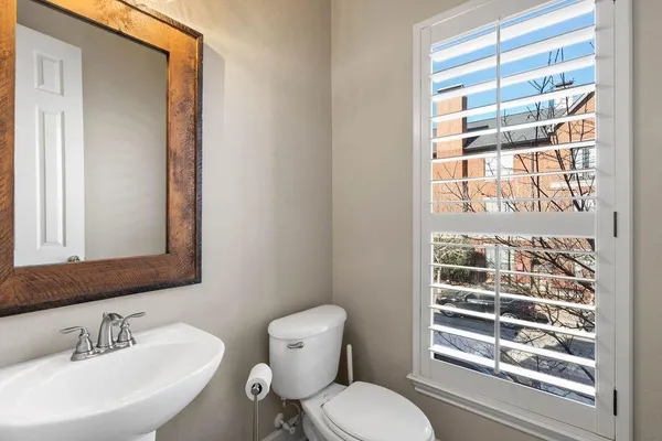 a bathroom with a toilet a sink and a window