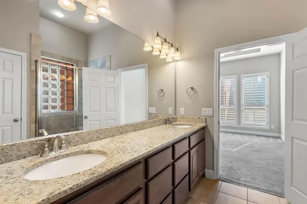 a bathroom with a granite countertop sink a light fixture and a mirror