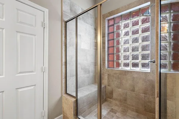 a bathroom with a shower and a glass door