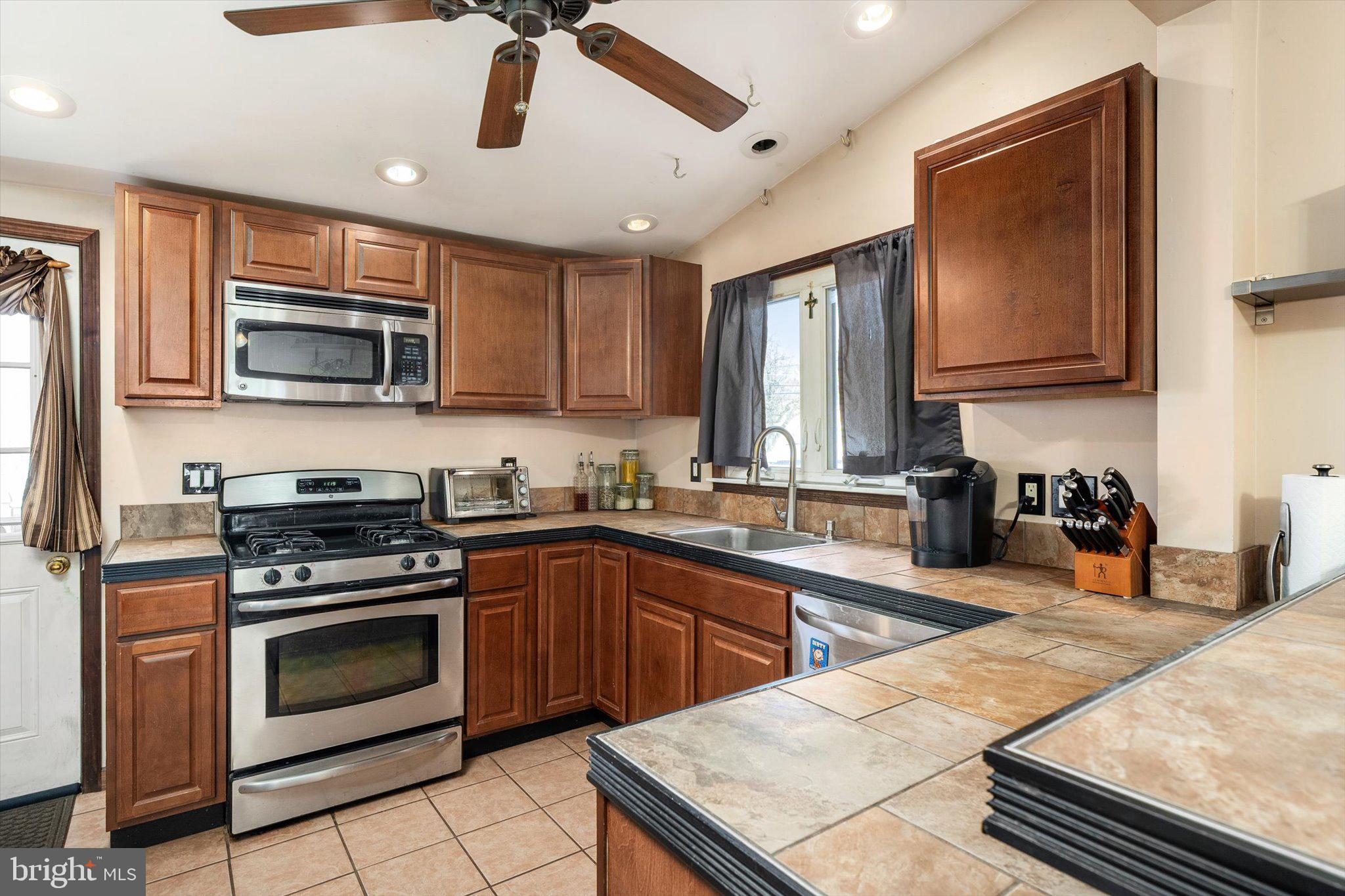 1013 West 5th Street Florence, NJ 08518 - Photo 12 of 21 a kitchen with stainless steel appliances granite countertop a stove top oven a sink dishwasher and white cabinets