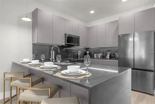 a kitchen with a sink a stove and chairs