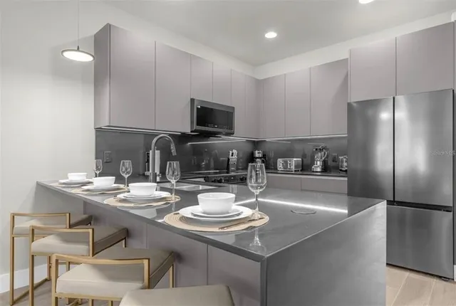 a kitchen with a sink a stove and chairs