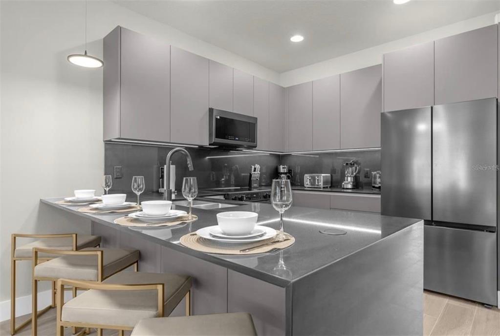 1411 Serendipity Lane Clermont, FL 34714 - Photo 12 of 15 a kitchen with a sink a stove and chairs