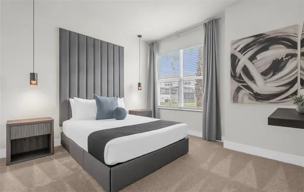 a bedroom with a bed and a painting on the wall