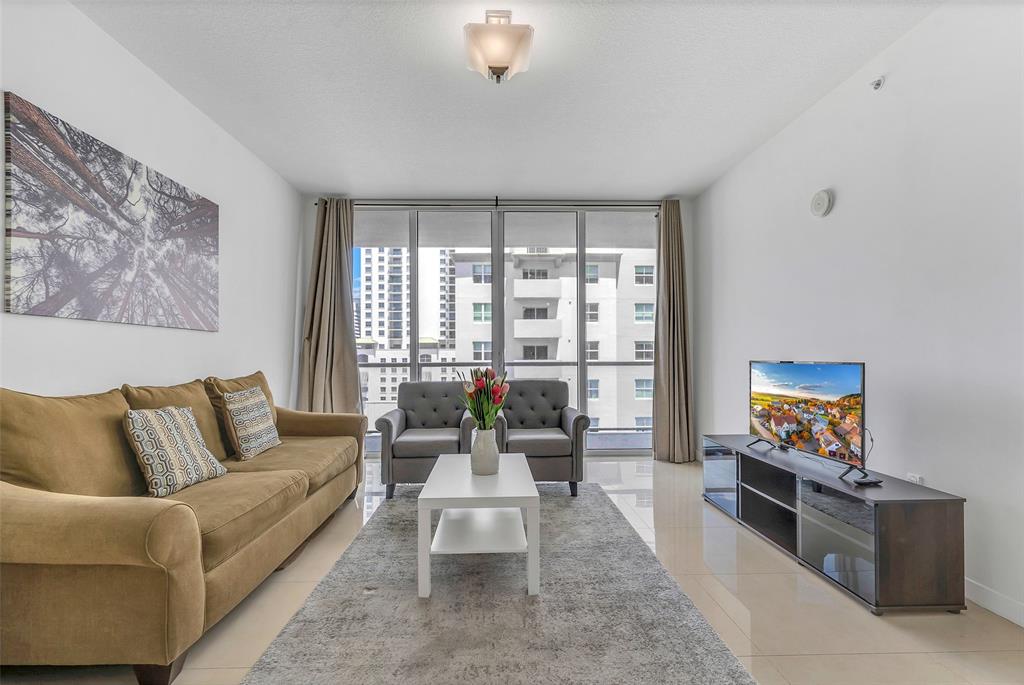 1111 Southwest 1st Avenue, Unit 1224N Miami, FL 33130 - Photo 4 of 37 a living room with furniture and a flat screen tv
