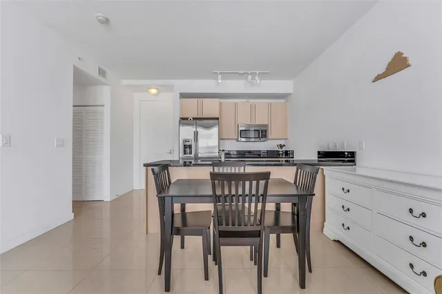 a kitchen with a table chairs refrigerator and cabinets