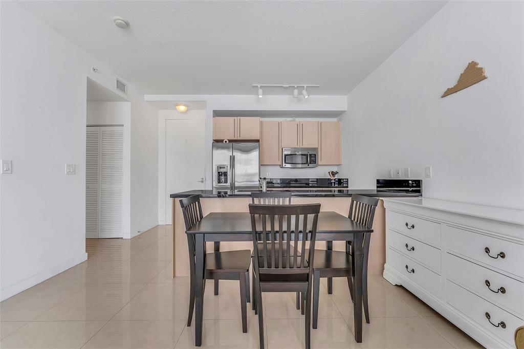 1111 Southwest 1st Avenue, Unit 1224N Miami, FL 33130 - Photo 7 of 37 a kitchen with a dining table chairs and cabinets
