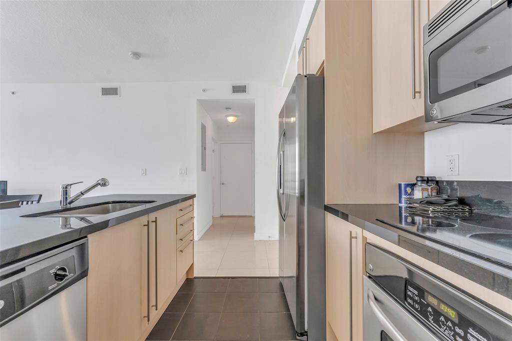 1111 Southwest 1st Avenue, Unit 1224N Miami, FL 33130 - Photo 9 of 37 a kitchen with stainless steel appliances granite countertop a sink stove and refrigerator