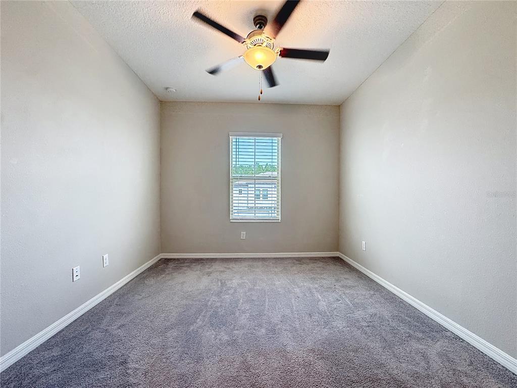 8069 Rolling Shell Trail Wesley Chapel, FL 33545 - Photo 12 of 26 an empty room with a window and a fan