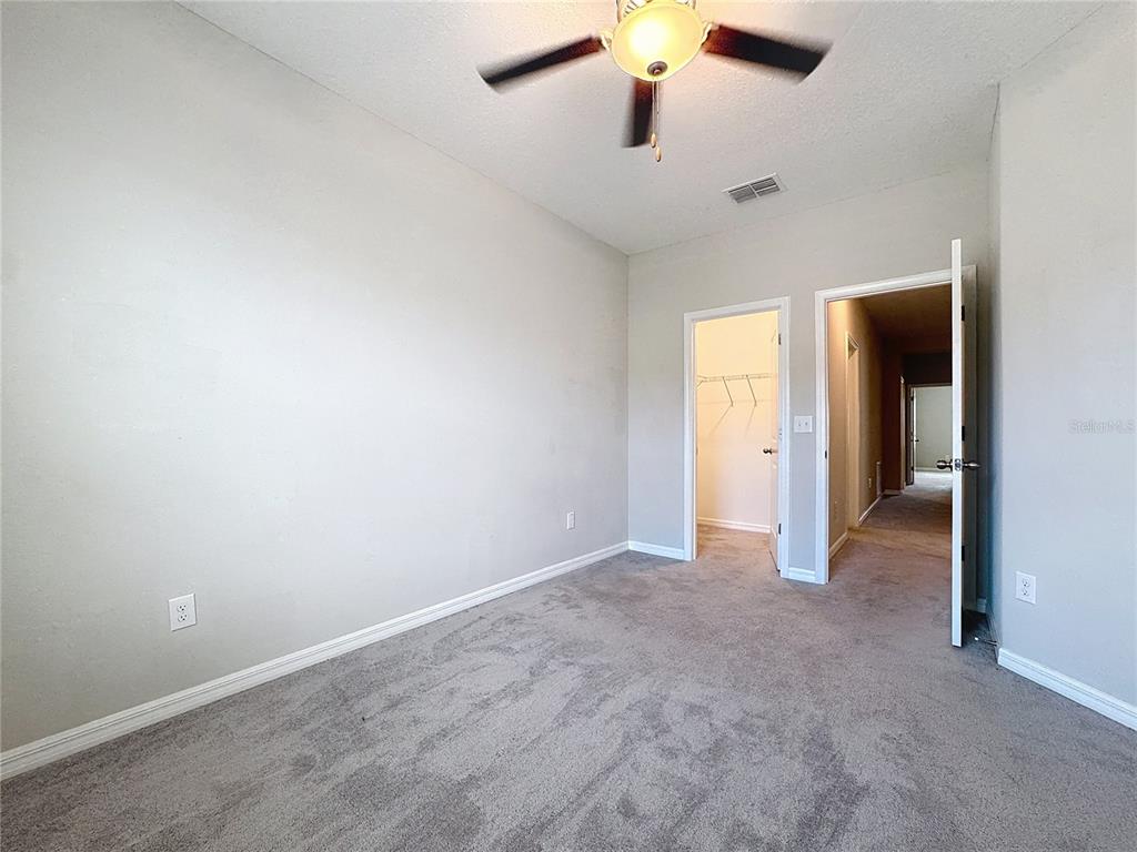 8069 Rolling Shell Trail Wesley Chapel, FL 33545 - Photo 13 of 26 an empty room with closet and a chandelier fan