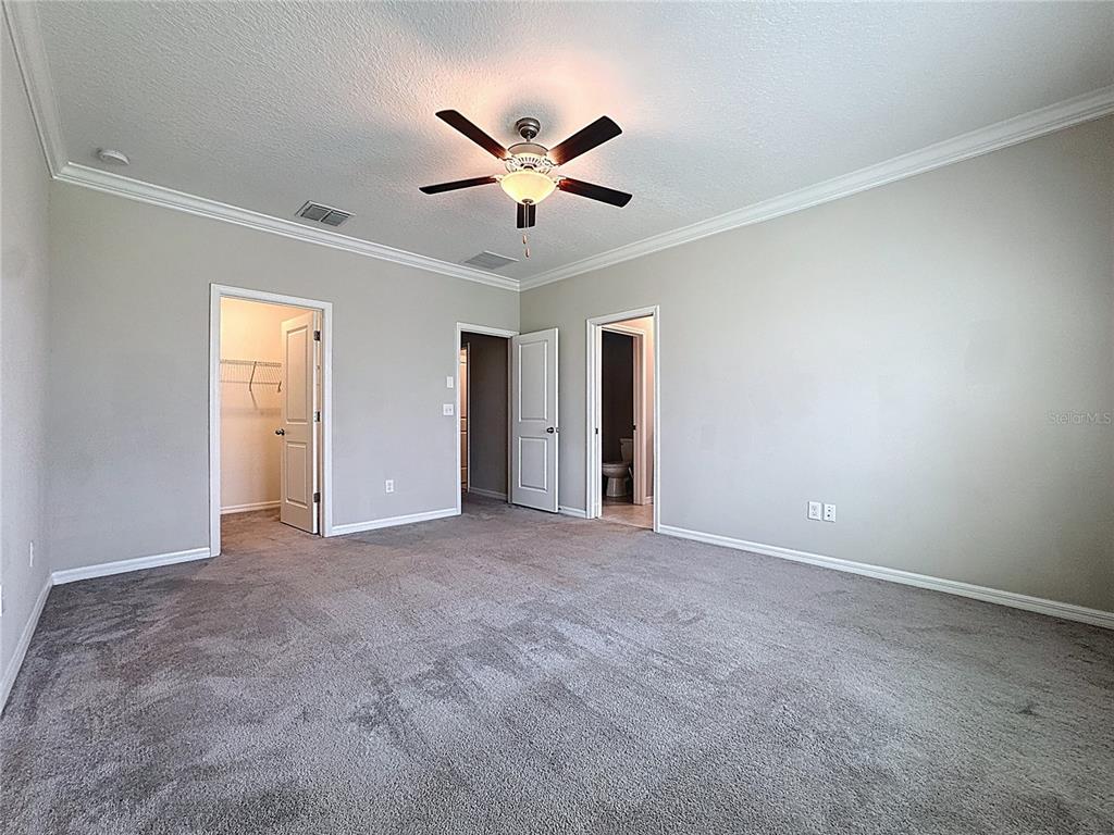 8069 Rolling Shell Trail Wesley Chapel, FL 33545 - Photo 14 of 26 a view of an empty room with a ceiling fan