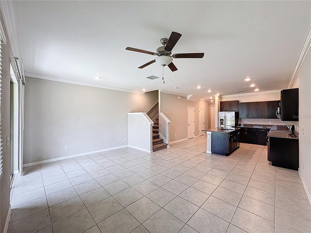 8069 Rolling Shell Trail Wesley Chapel, FL 33545 - Photo 3 of 26 a view of a living room with kitchen furniture and a ceiling fan