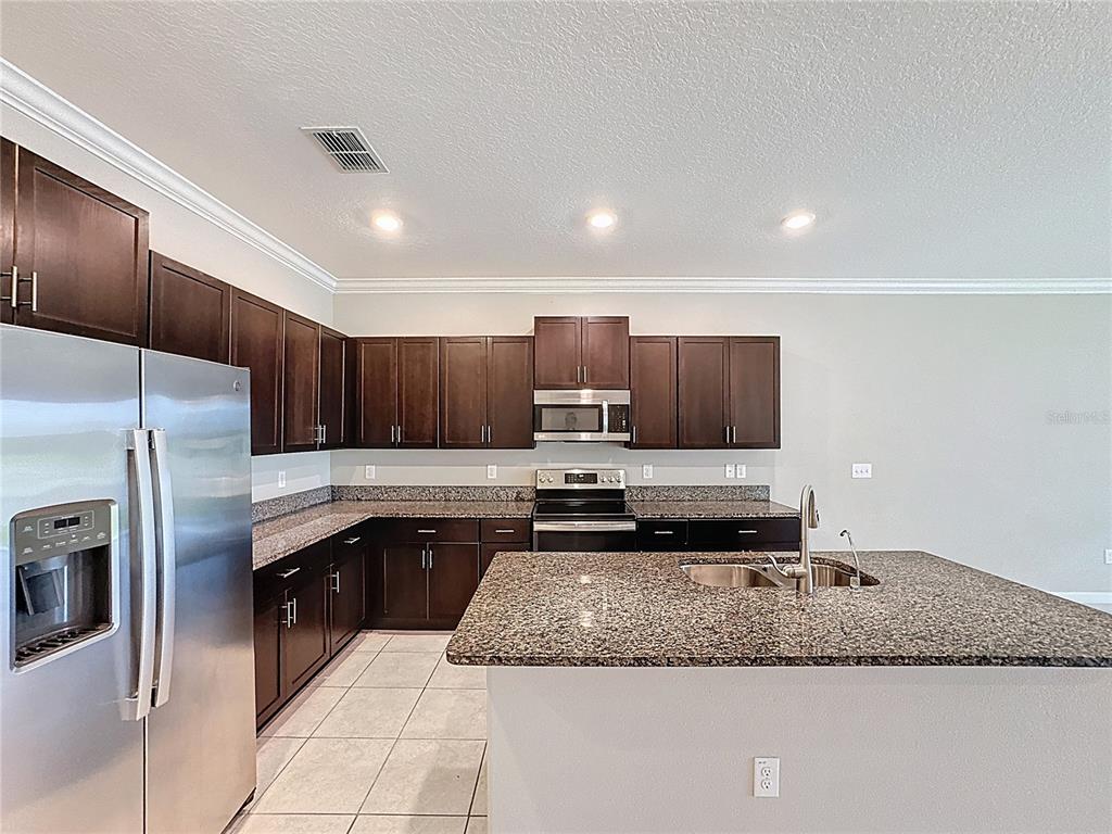 8069 Rolling Shell Trail Wesley Chapel, FL 33545 - Photo 5 of 26 a kitchen with a refrigerator sink and cabinets