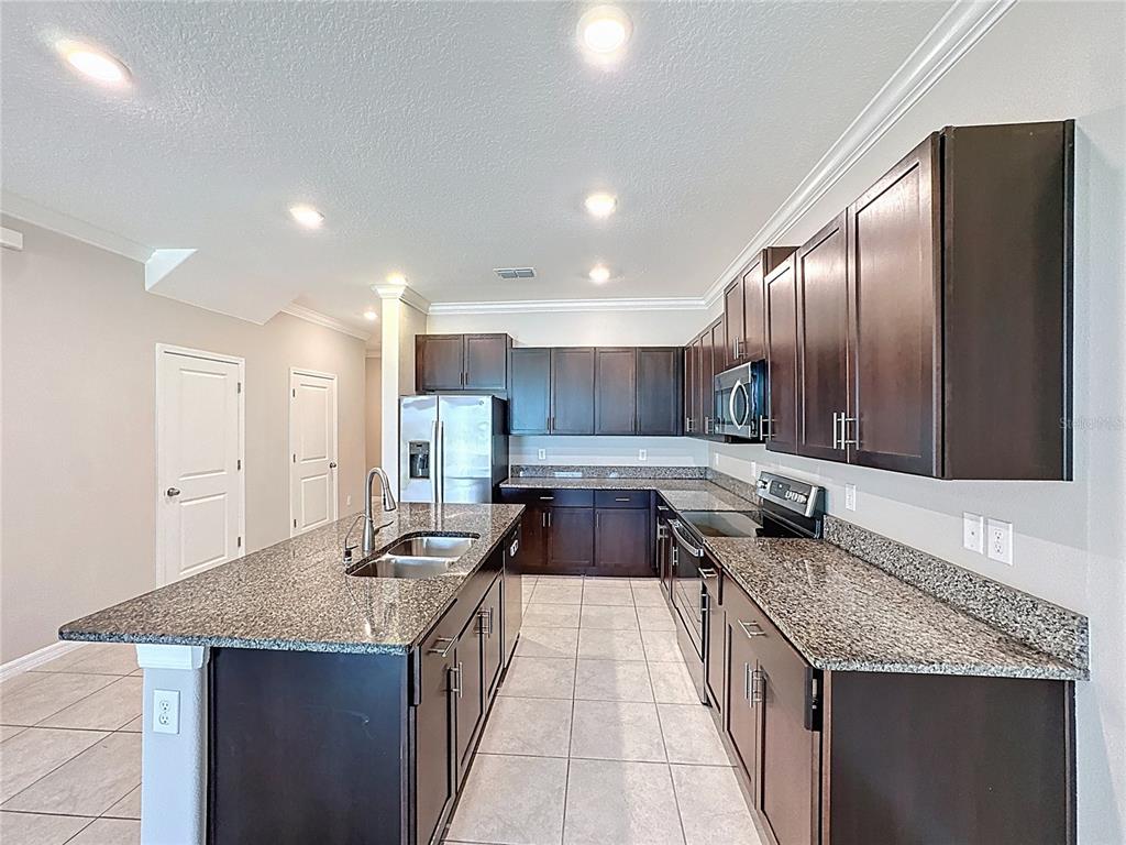 8069 Rolling Shell Trail Wesley Chapel, FL 33545 - Photo 6 of 26 a kitchen with granite countertop stainless steel appliances lots of counter top space