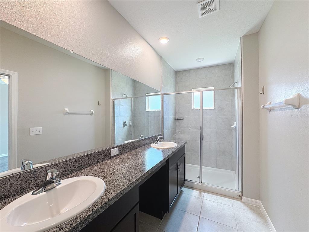 8069 Rolling Shell Trail Wesley Chapel, FL 33545 - Photo 7 of 26 a bathroom with a granite countertop double vanity sink and mirror