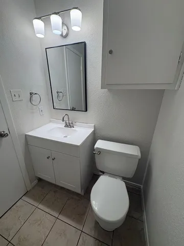 a bathroom with a toilet sink and mirror