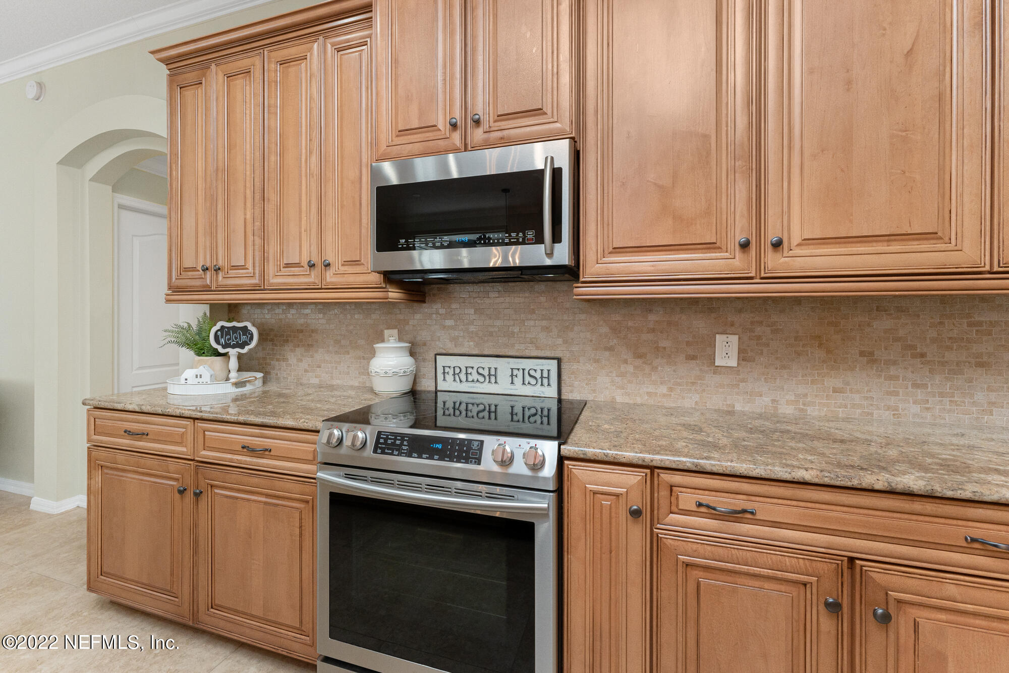 8713 Reedy Branch Drive Jacksonville, FL 32256 - Photo 4 of 38 a kitchen with stainless steel appliances granite countertop white cabinets and a stove top oven