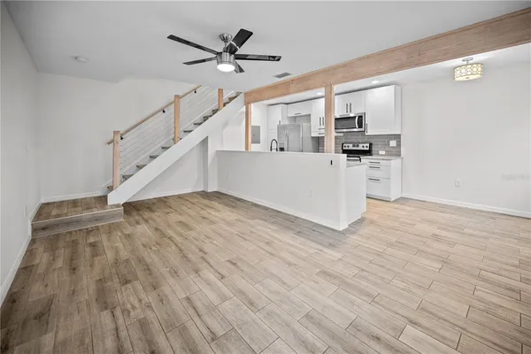 a view of a livingroom with wooden floor and stairs