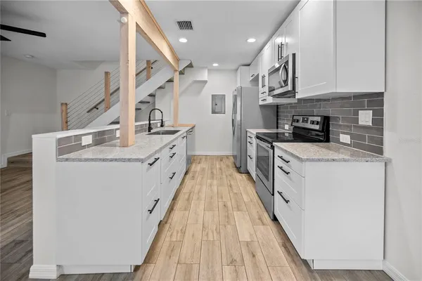 a kitchen with stainless steel appliances granite countertop a stove a sink and a refrigerator