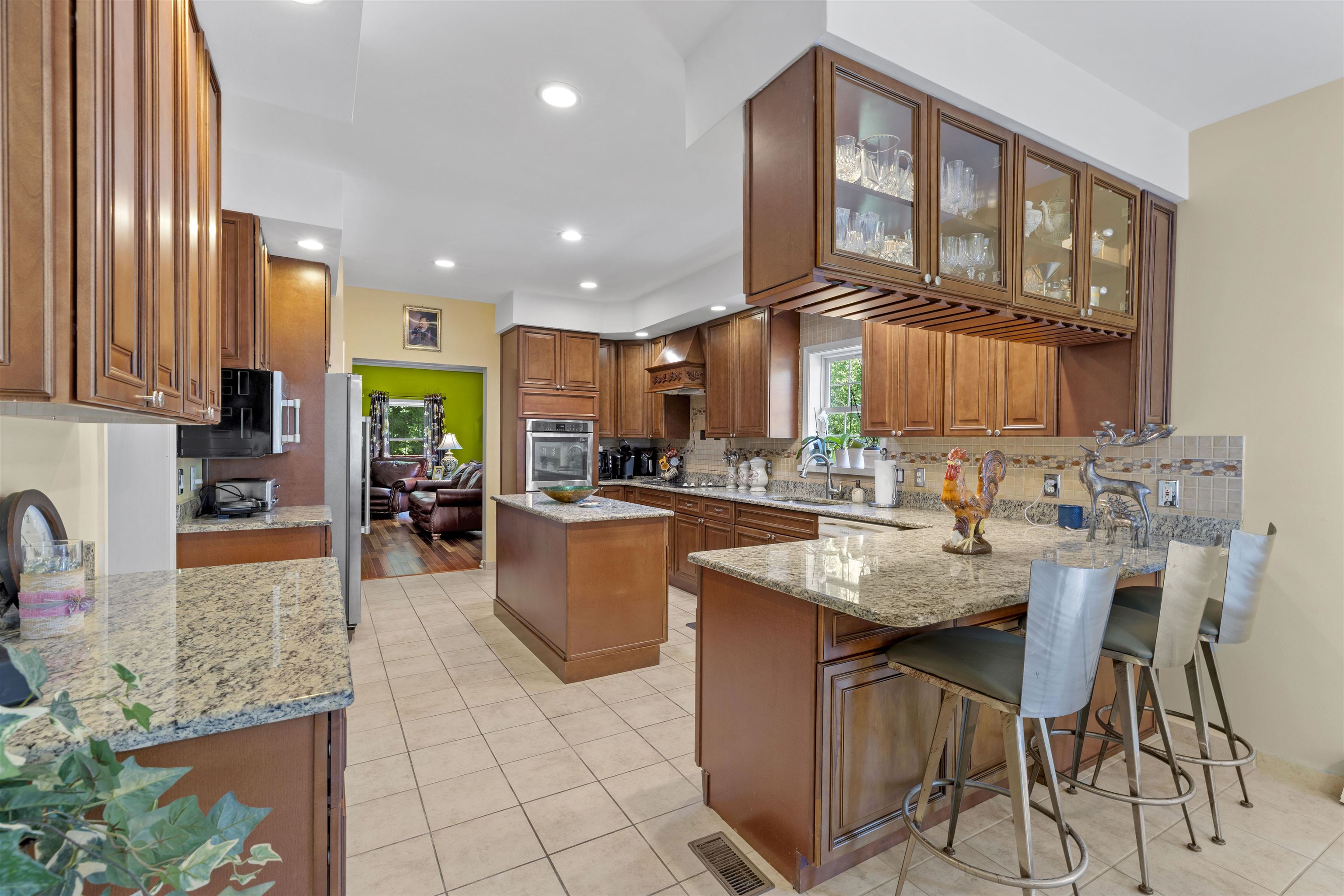 551 Shunpike Road Cape May Court House, NJ 08210 - Photo 8 of 47 a kitchen with stainless steel appliances granite countertop a stove a sink a oven a dining table and chairs with white cabinets