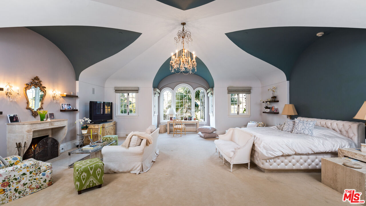 2733 Sycamore Canyon Road Montecito, CA 93108 - Photo 23 of 30 a bedroom with furniture a fireplace and a chandelier