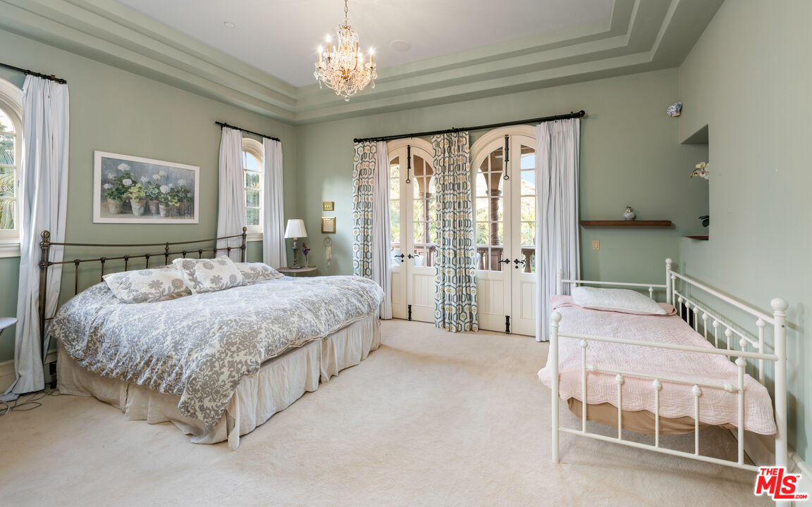 2733 Sycamore Canyon Road Montecito, CA 93108 - Photo 26 of 30 a spacious bedroom with a large bed and a chandelier