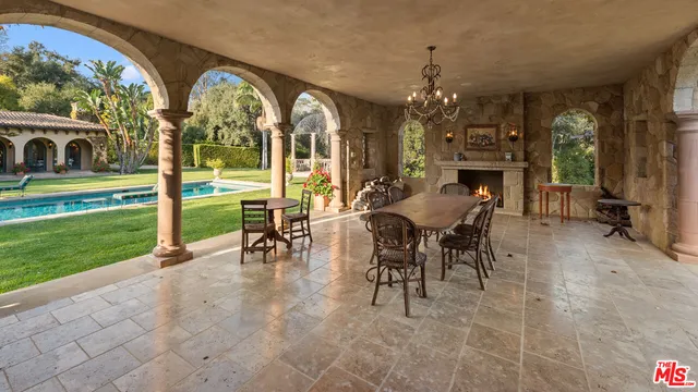 a view of a patio with a table and chairs under an umbrella