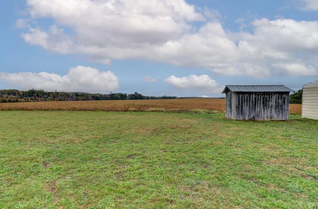 a backyard of a house with lots of green space and fence