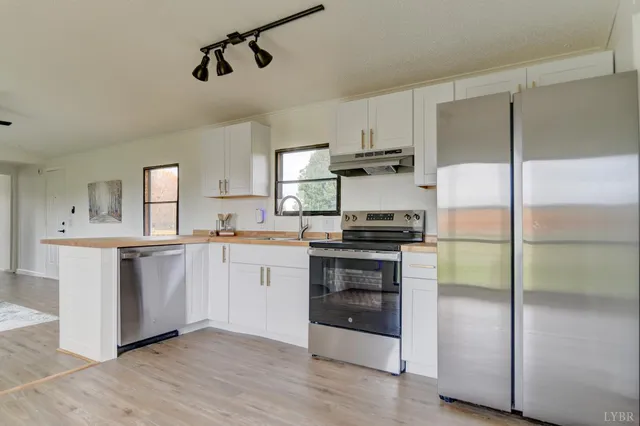 a kitchen with a refrigerator and white cabinets