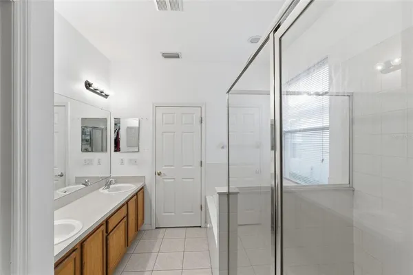 a bathroom with a double vanity sink a mirror and a shower