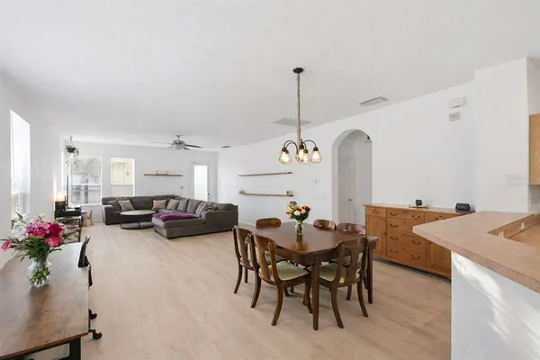 a view of a dining room and livingroom with furniture wooden floor a chandelier