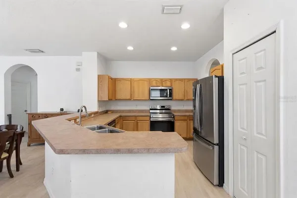 a kitchen with stainless steel appliances granite countertop a refrigerator a sink and a stove