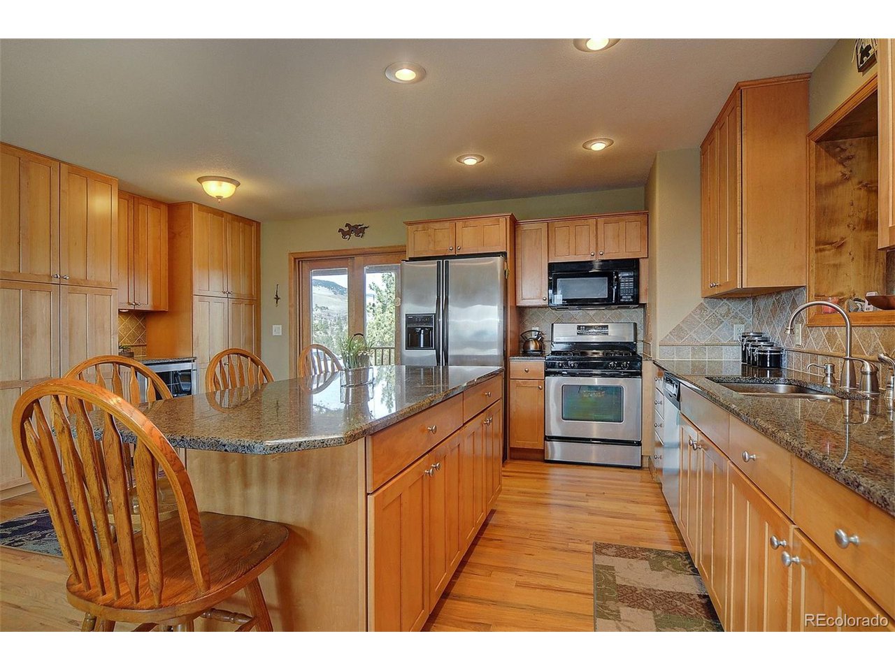 1251 Antelope Trail Cotopaxi, CO 81223 - Photo 13 of 38 a kitchen with stainless steel appliances granite countertop a refrigerator a sink a stove and a wooden cabinets