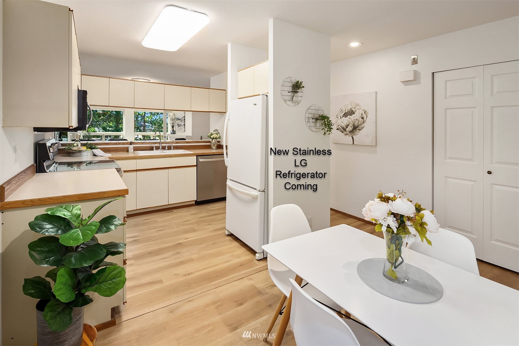 605 5th Street, Unit B 303 Kirkland, WA 98033 - Photo 6 of 18 a kitchen with stainless steel appliances a sink a table and chairs