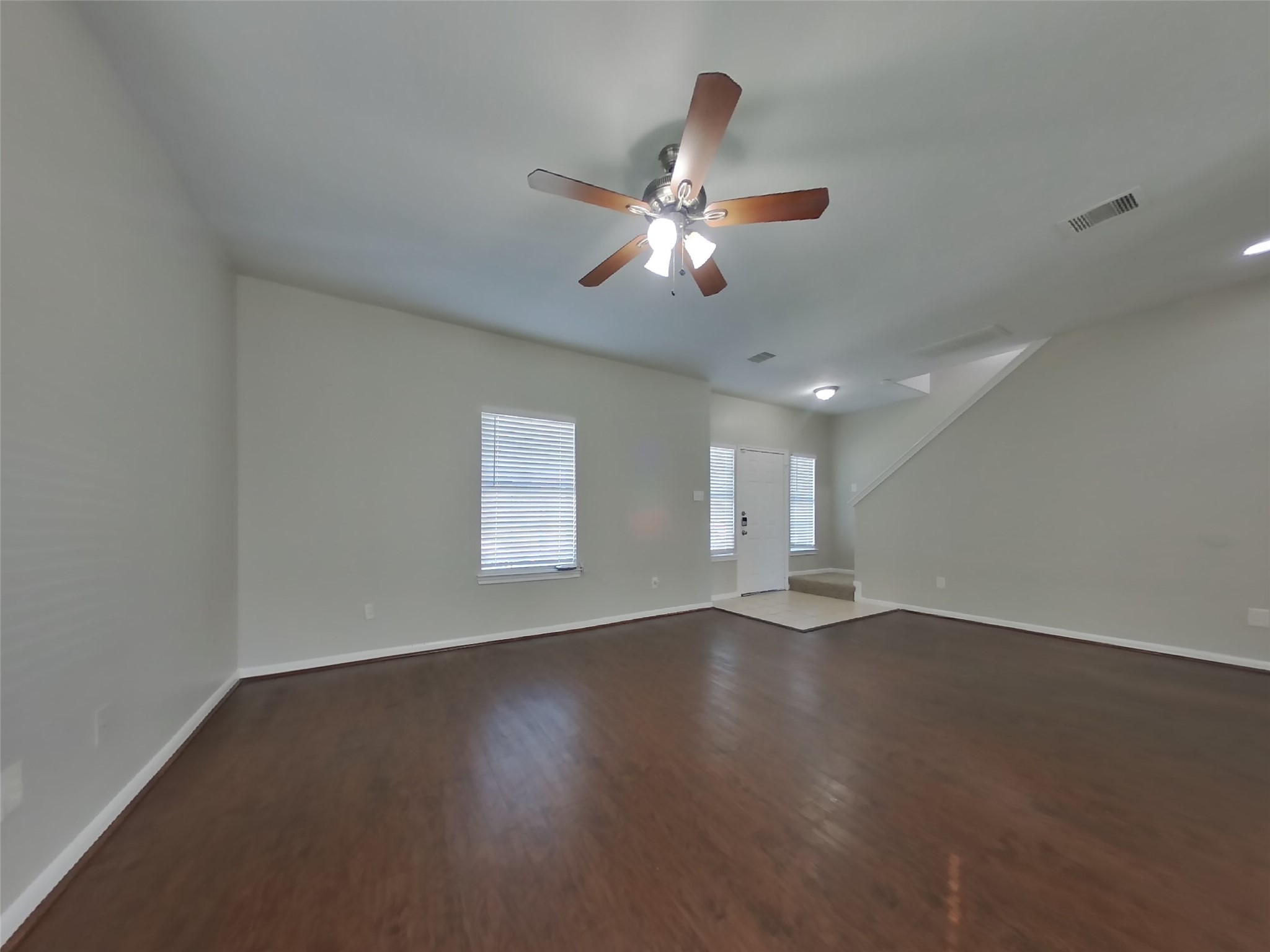 11415 Carla Street Houston, TX 77076 - Photo 2 of 15 an empty room with wooden floor ceiling fan and windows