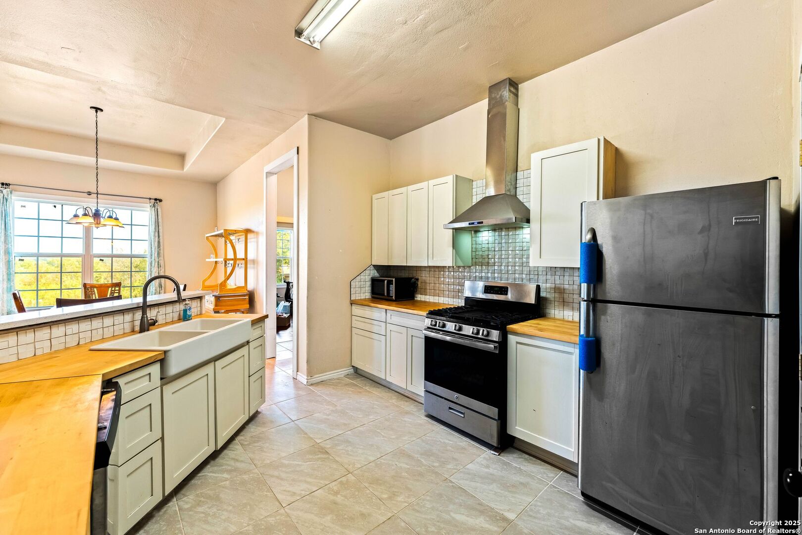 2211 Geneva Street Castroville, TX 78009 - Photo 10 of 41 a kitchen with stainless steel appliances granite countertop a refrigerator a stove and a sink