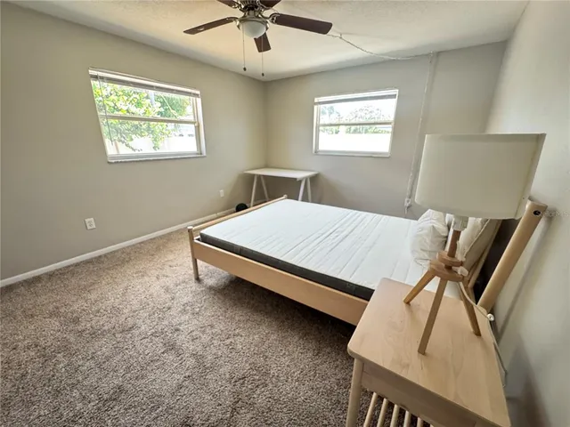 a bed sitting in a bedroom next to a window