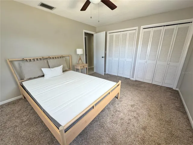 a large bed sitting in a bedroom next to a window