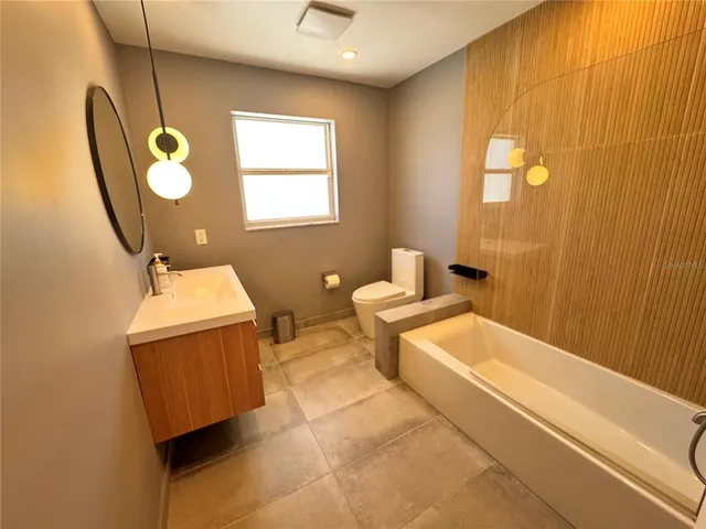 a bathroom with a sink mirror and a bathtub