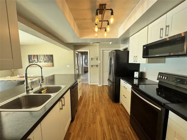 a kitchen with stainless steel appliances a sink stove and refrigerator