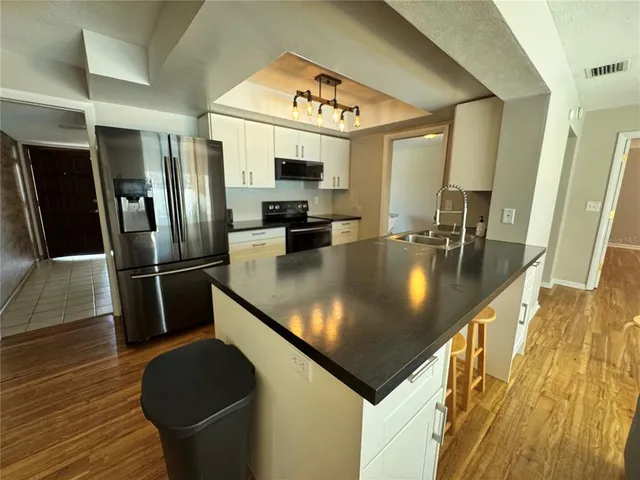 a kitchen with stainless steel appliances granite countertop a sink a stove and a refrigerator