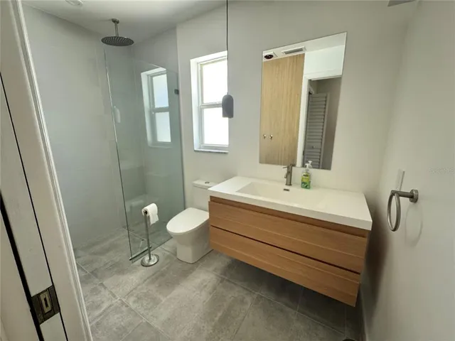 a bathroom with a sink a toilet and shower