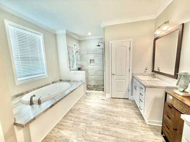 a spacious bathroom with a granite countertop tub sink and mirror